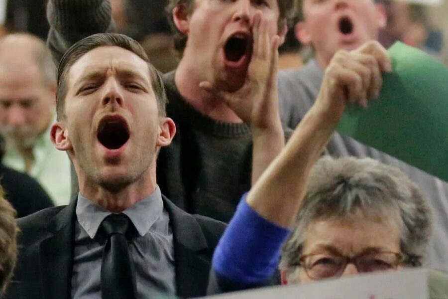 People protesting at a town hall meeting