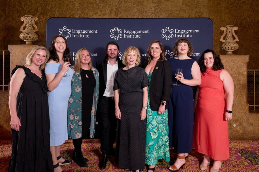 Eight members of the Capire team attend the 2025 Annual Conference Gala Dinner. They are standing in a group and smiling, dressed in formal attire (colourful dresses and suit).