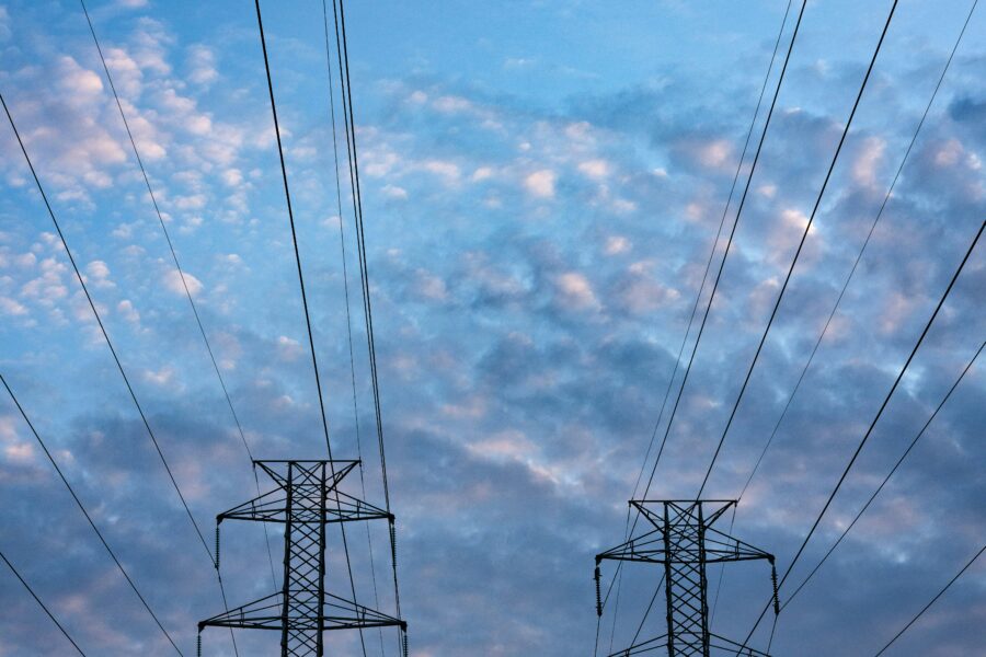 Transmission lines, set against a cloudy blue sky