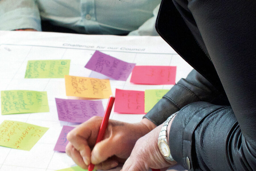 Participant writing on a post-it note during a Capire workshop