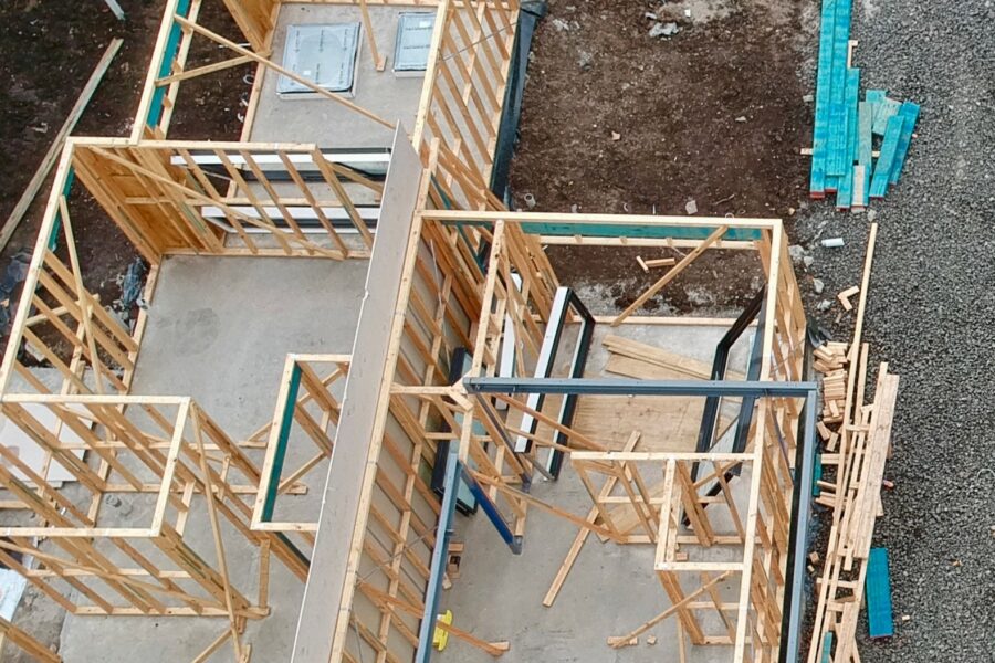 Ariel view of a house under construction. Timber frame and building materials are visible
