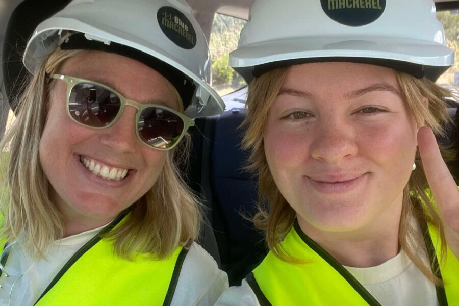 Capire engagement consultants on their way to an event. They are both smiling and wearing Blue Mackerel yellow hi-vis vests and pale-blue hard hats